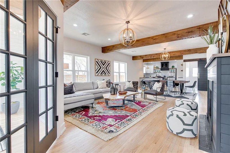 Living area with wood beams and French doors leading into office
