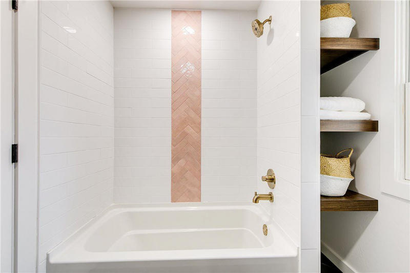 White bathtub with brick accent wall