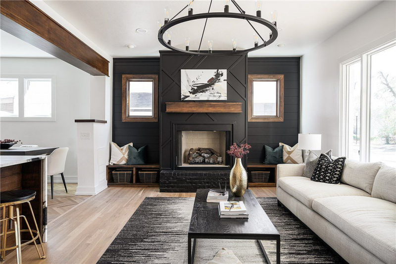 Living room with black accent wall, fireplace, and wooden mantle