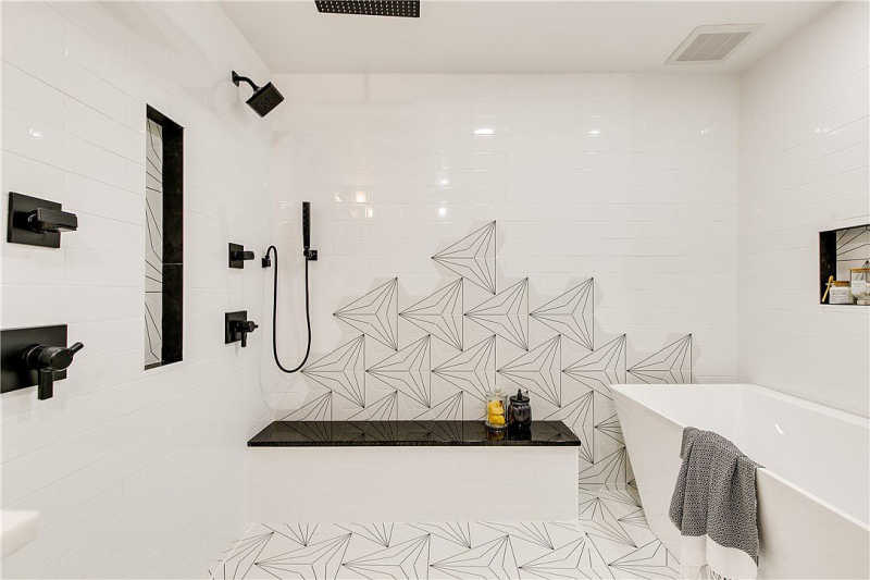 Spa shower with seating, black hardware, and patterned tile accent wall