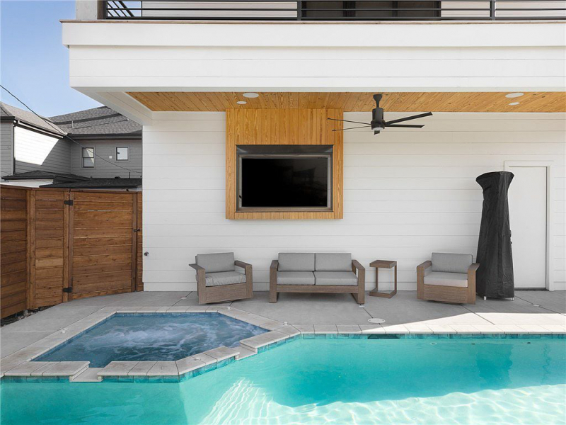 Pool area with outdoor seating and mounted TV