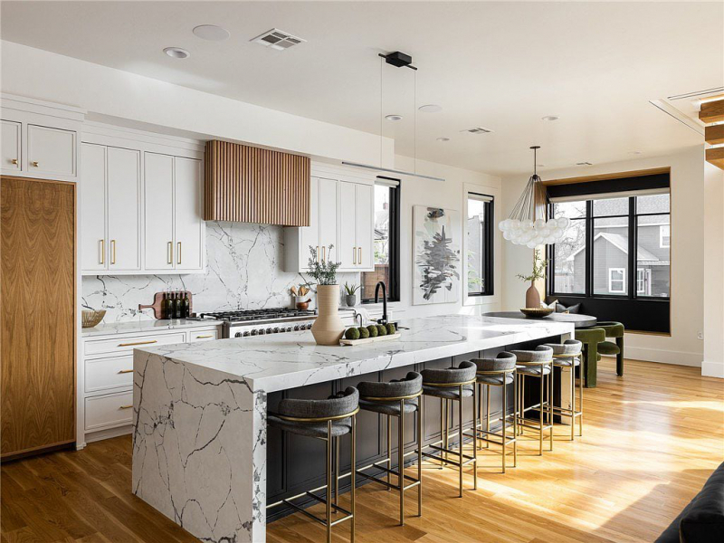 Kitchen with oversize white quartz waterfall island and seating