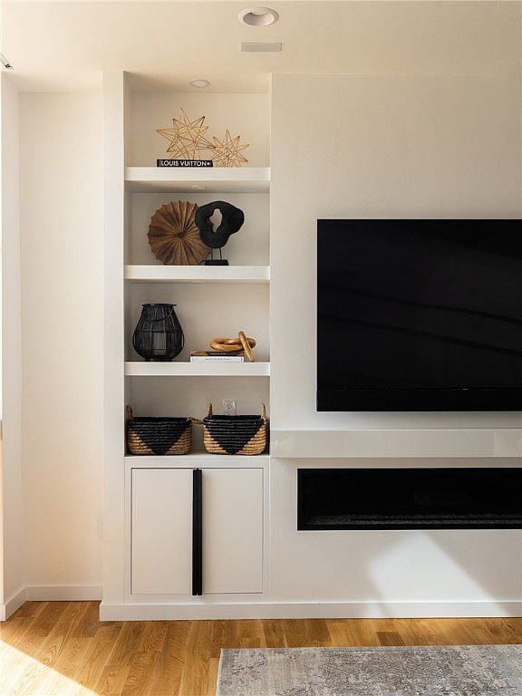 Living room TV with modern white built-in bookshelves