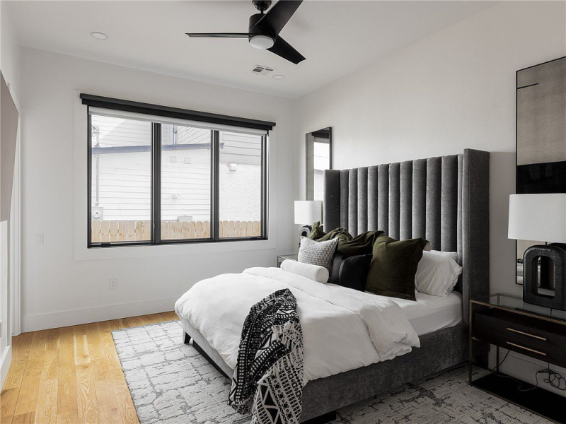 Bedroom with tall gray bedframe and white sheets