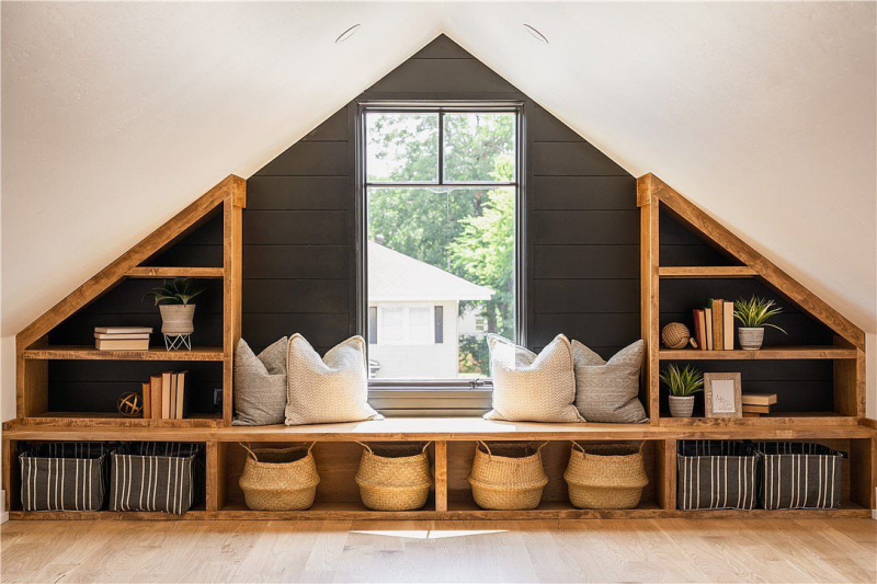 Attic loft area with reading nook and built-in bookshelves