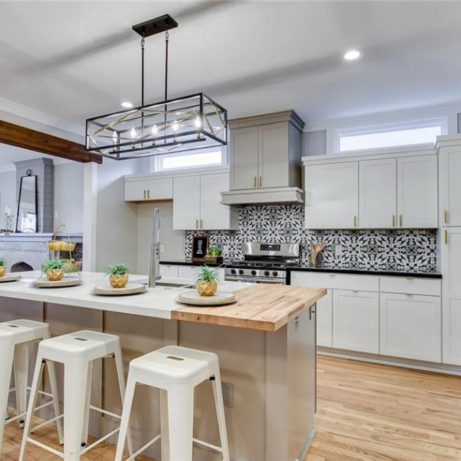 Kitchen with butcher block island, white cabinets, and patterned backsplash