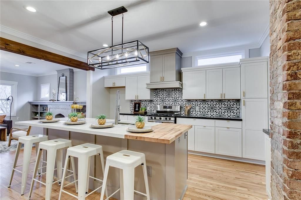 Kitchen with butcher block island, white cabinets, and patterned backsplash