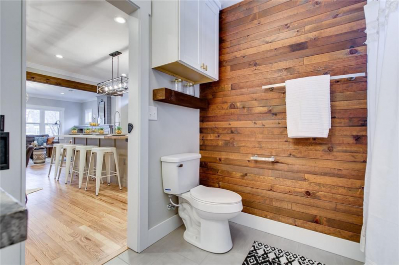 Half bathroom with wood panel accent wall