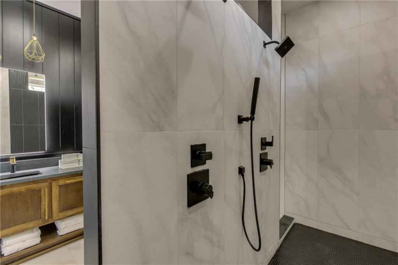 Two-way entry shower with marble tile and black hardware