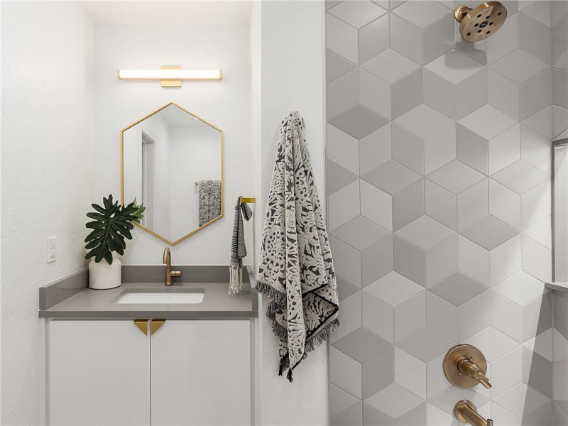 Vanity with hexagon mirror and rhombus tiles