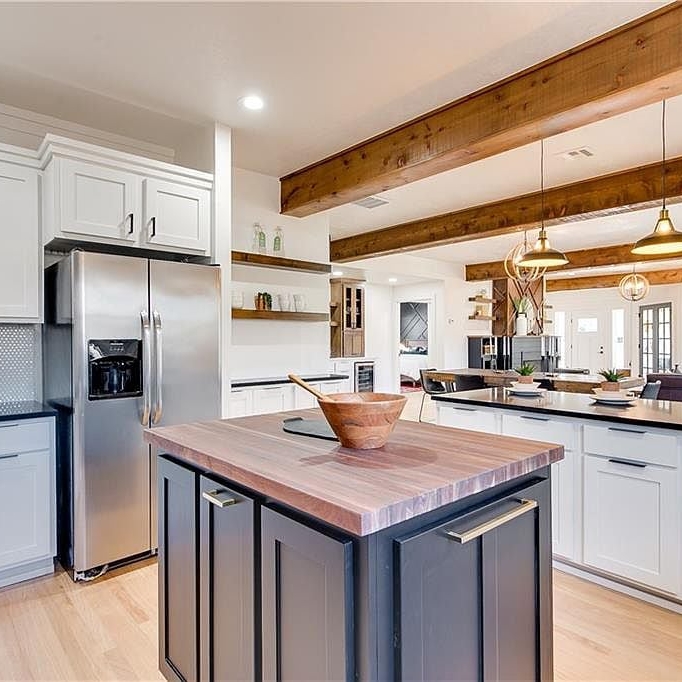 Kitchen with butcher block island and wooden header beams